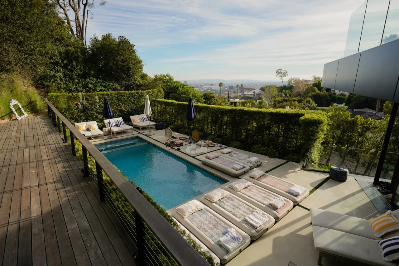 Sunlit pool prepared with floating mattresses for an Om Floating sound journey